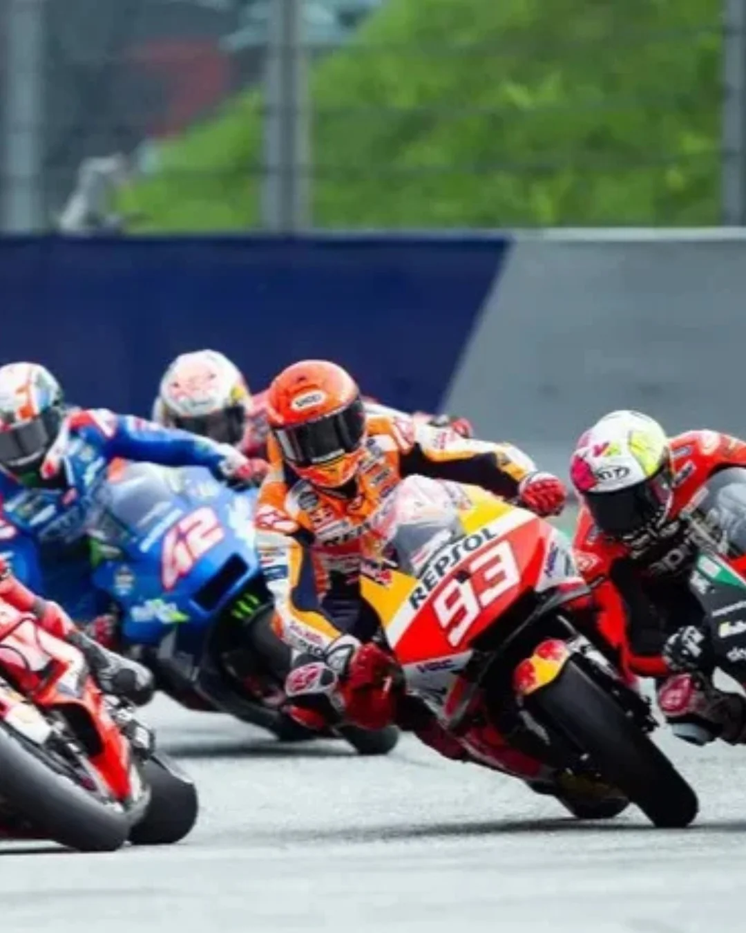 "Motores rugindo e disputas milimétricas em uma curva de tirar o fôlego! Esta imagem captura a essência da MotoGP, antecipando a adrenalina que tomará conta do Brasil em 2026. Pilotos no limite, como o icônico #93 da Repsol Honda e a poderosa Ducati em primeiro plano, mergulham em uma batalha intensa, simbolizando o espetáculo inesquecível que aguarda os fãs brasileiros no retorno do Grande Prêmio. Prepare-se para a velocidade, a paixão e a história sendo reescrita!"